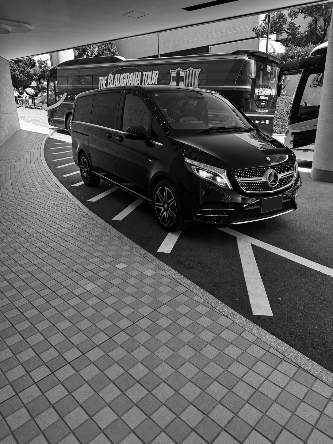 Black Mercedes-Benz V-Class alongside the FC Barcelona team coach